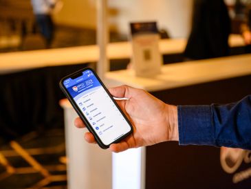 Hand holding smartphone displaying an app.
