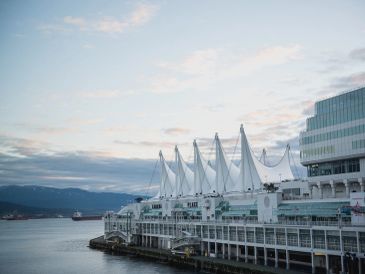 Waterfront building with distinctive white sails.