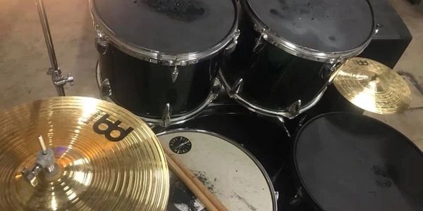 Top view of a drum set with sticks on the snare and a cymbal.