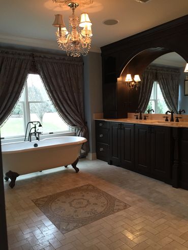 Elegant bathroom with clawfoot tub and chandelier.