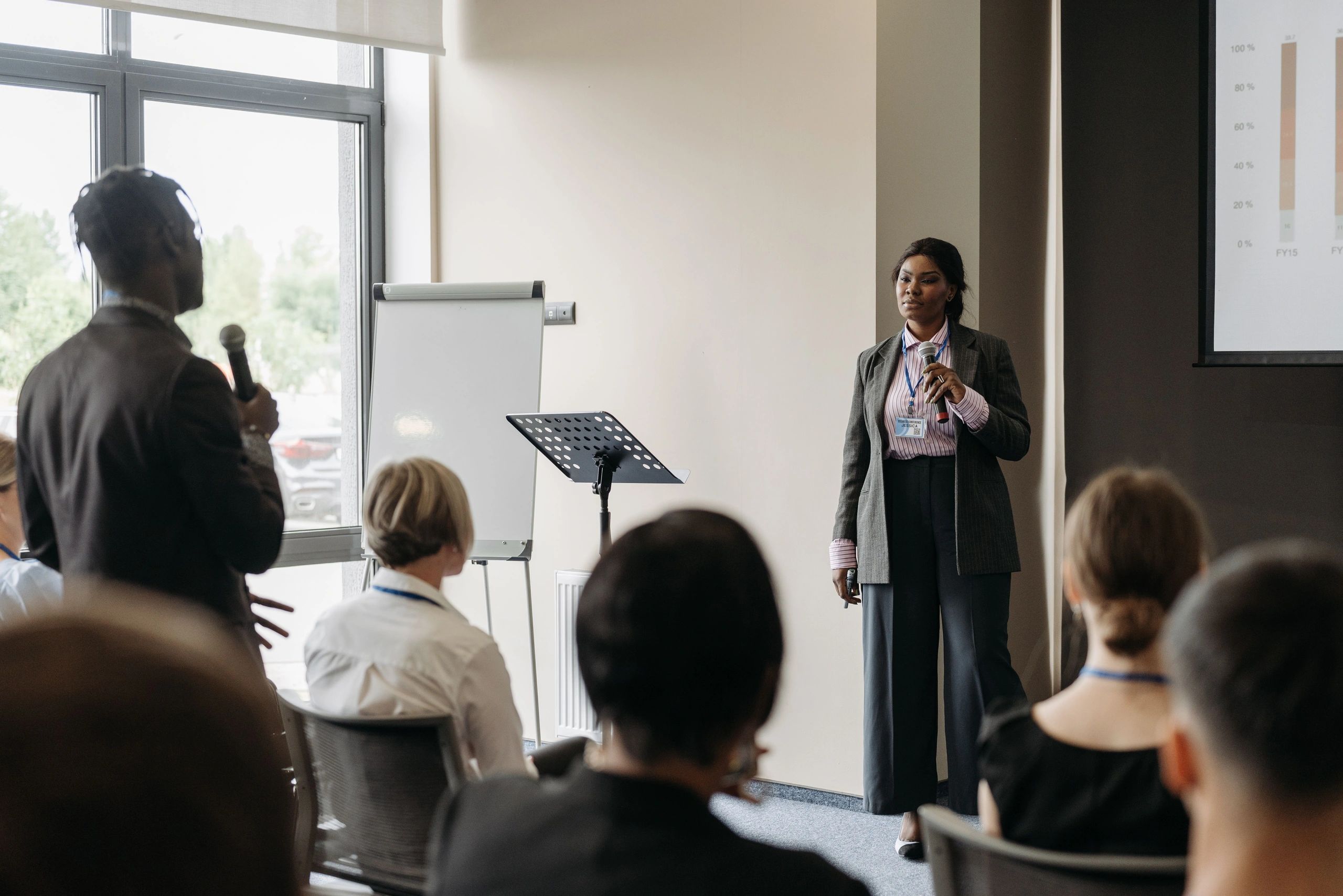 Woman giving a presentation while audience listens.