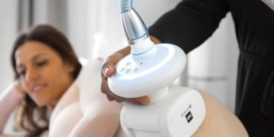 Woman undergoing a beauty treatment with a handheld device.