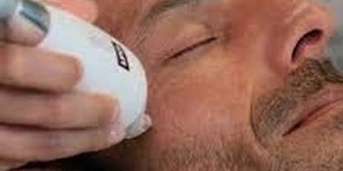 Person receiving facial treatment with a skincare device.