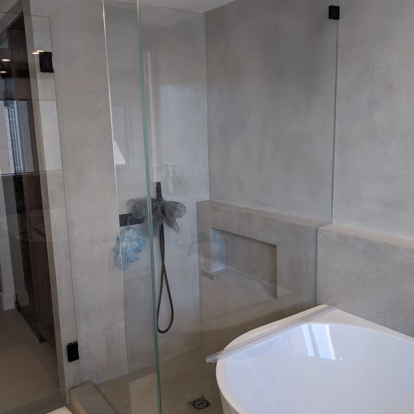 Minimalist bathroom with glass shower and modern bathtub.