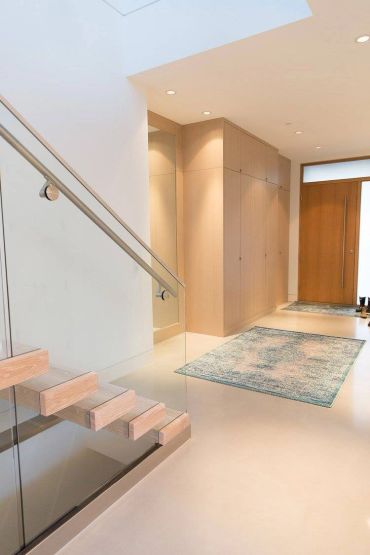 Minimalist interior with floating wooden stairs and a sleek hallway.