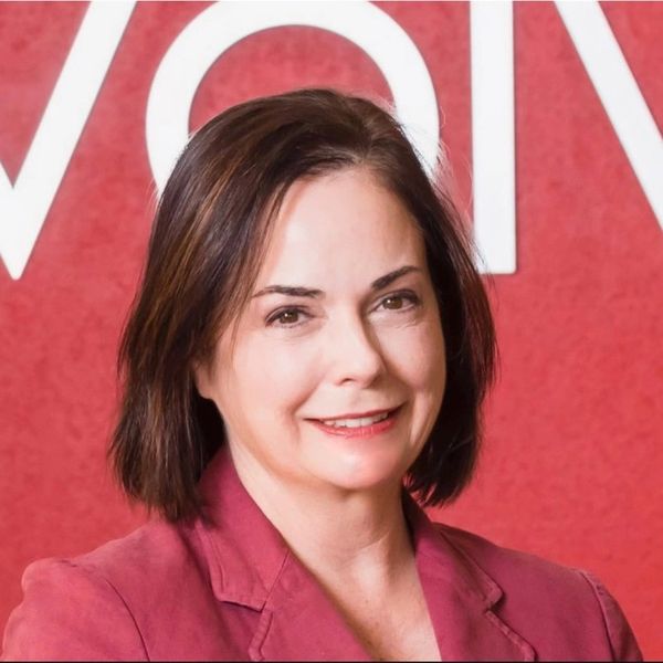 Smiling woman against a red background.