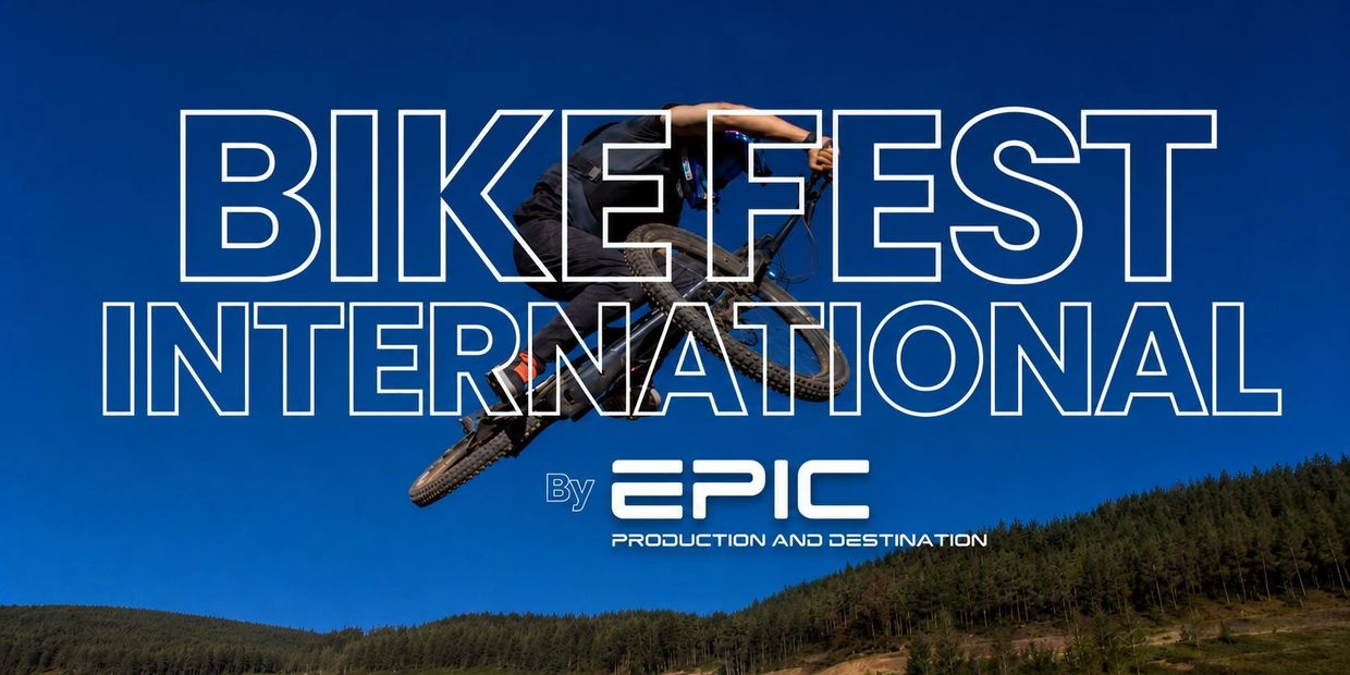 Mountain biker performing a jump under blue sky at BikeFest International.