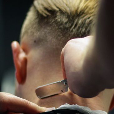 Barber uses razor for a skin fade.