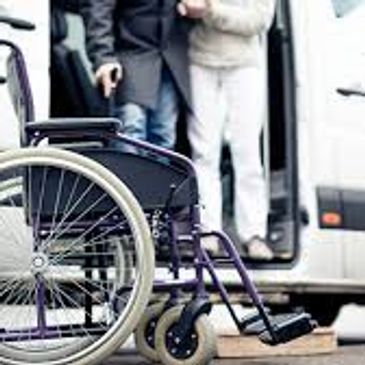 Wheelchair positioned near a vehicle for accessible transport.