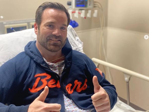 Mike Lowe in hospital bed giving thumbs up