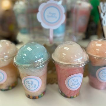 Colorful cotton candy cups labeled 'Fluff Stuff' with a birthday gift in the background.