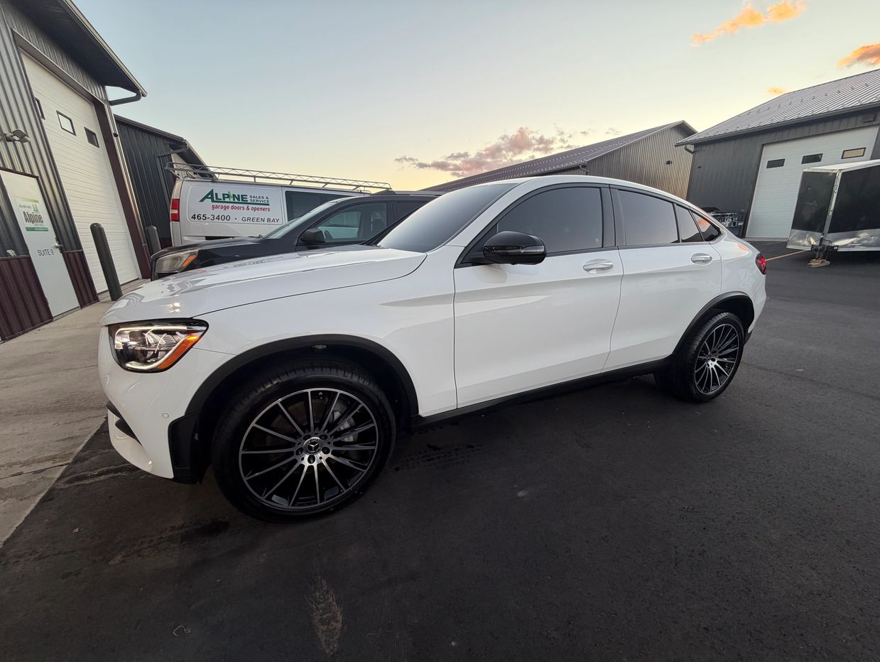 White luxury SUV with tinted windows parked outside.