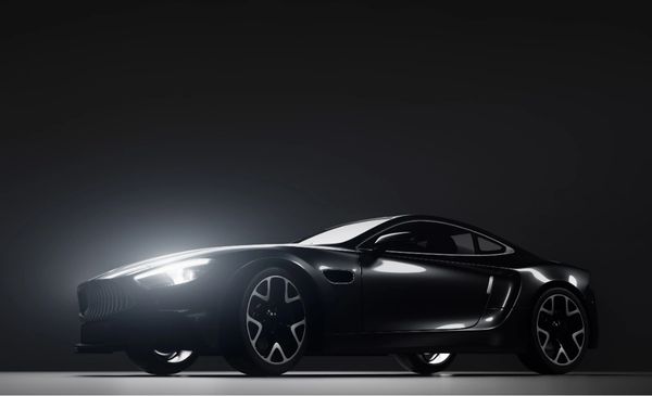 Sleek black sports car illuminated against a dark background.