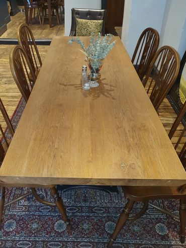 Long oak slab table with repurposed mangle legs