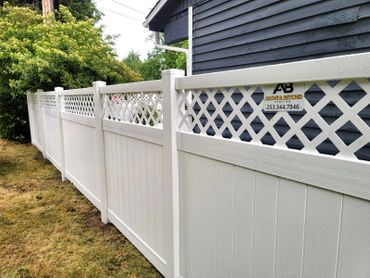 White vinyl fence with lattice top panels along a yard.