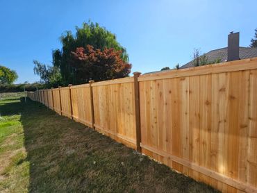A long wooden fence under a clear blue sky.