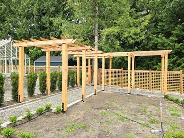 Wooden pergola structure in a garden under construction.