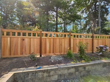 Newly installed wooden fence in a backyard garden area.