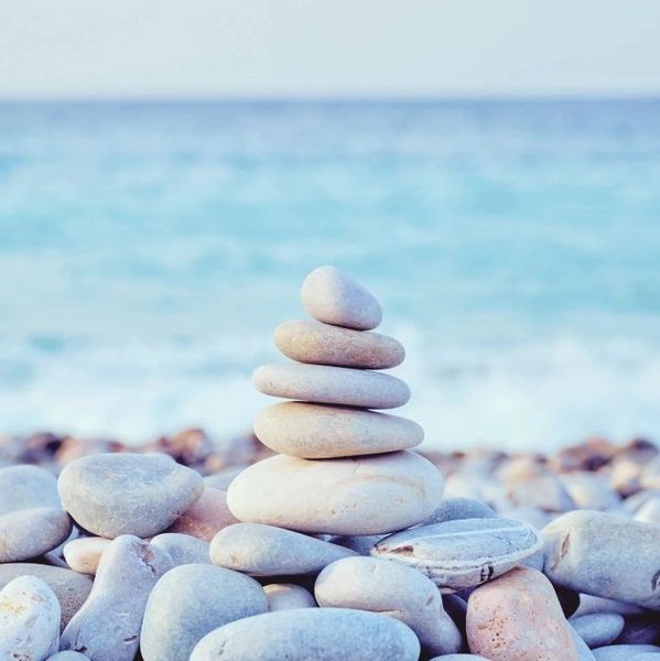 Stacked rocks against an ocean background 