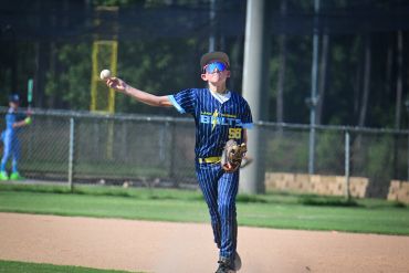 Young baseball player throwing a ball on the field.