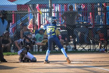 A youth baseball batter prepares to hit the ball.