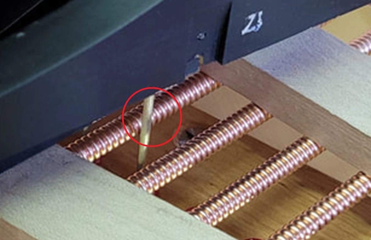 Damper wire very close to bass string on grand piano 