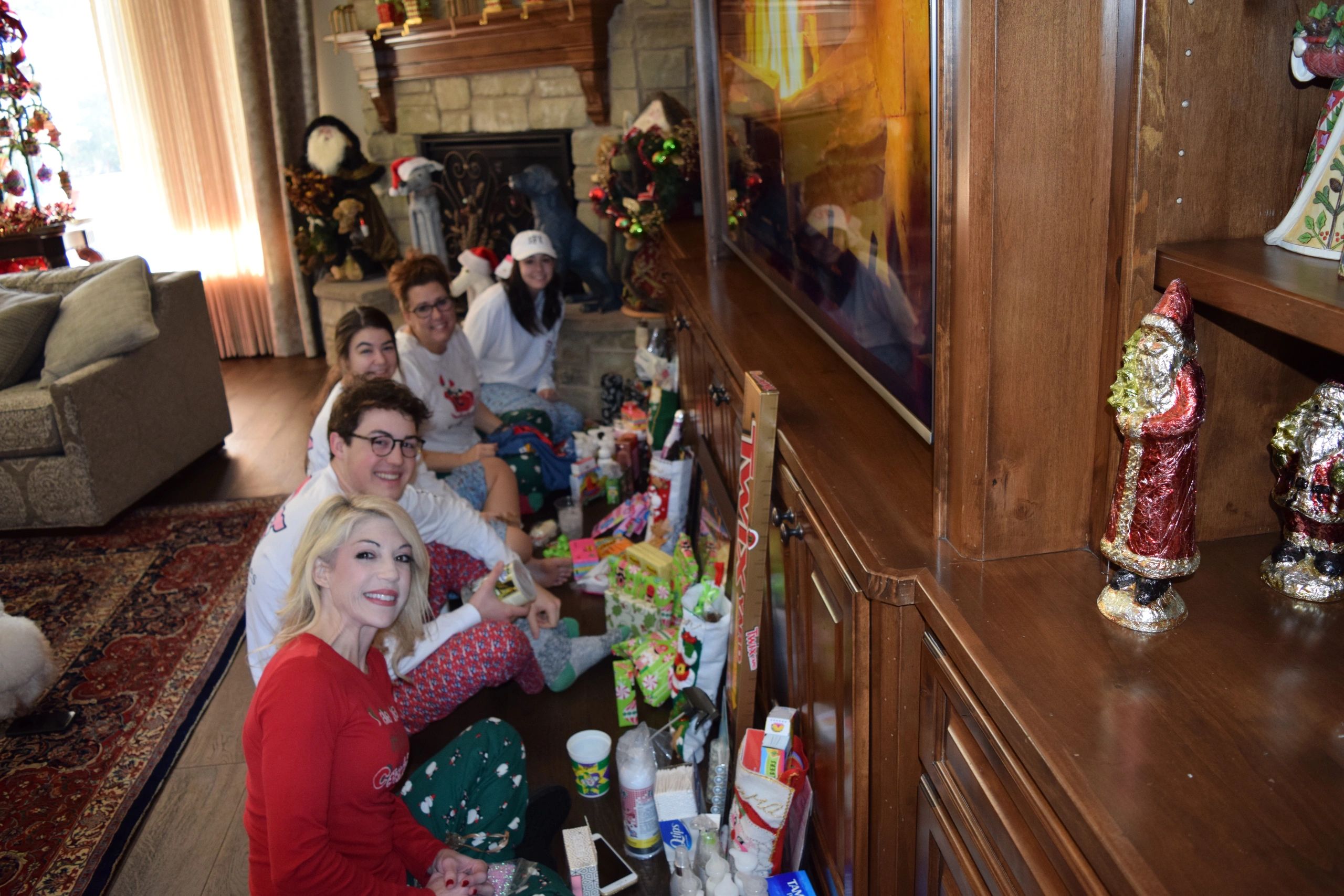 Family enjoying Christmas morning with gifts and TV.