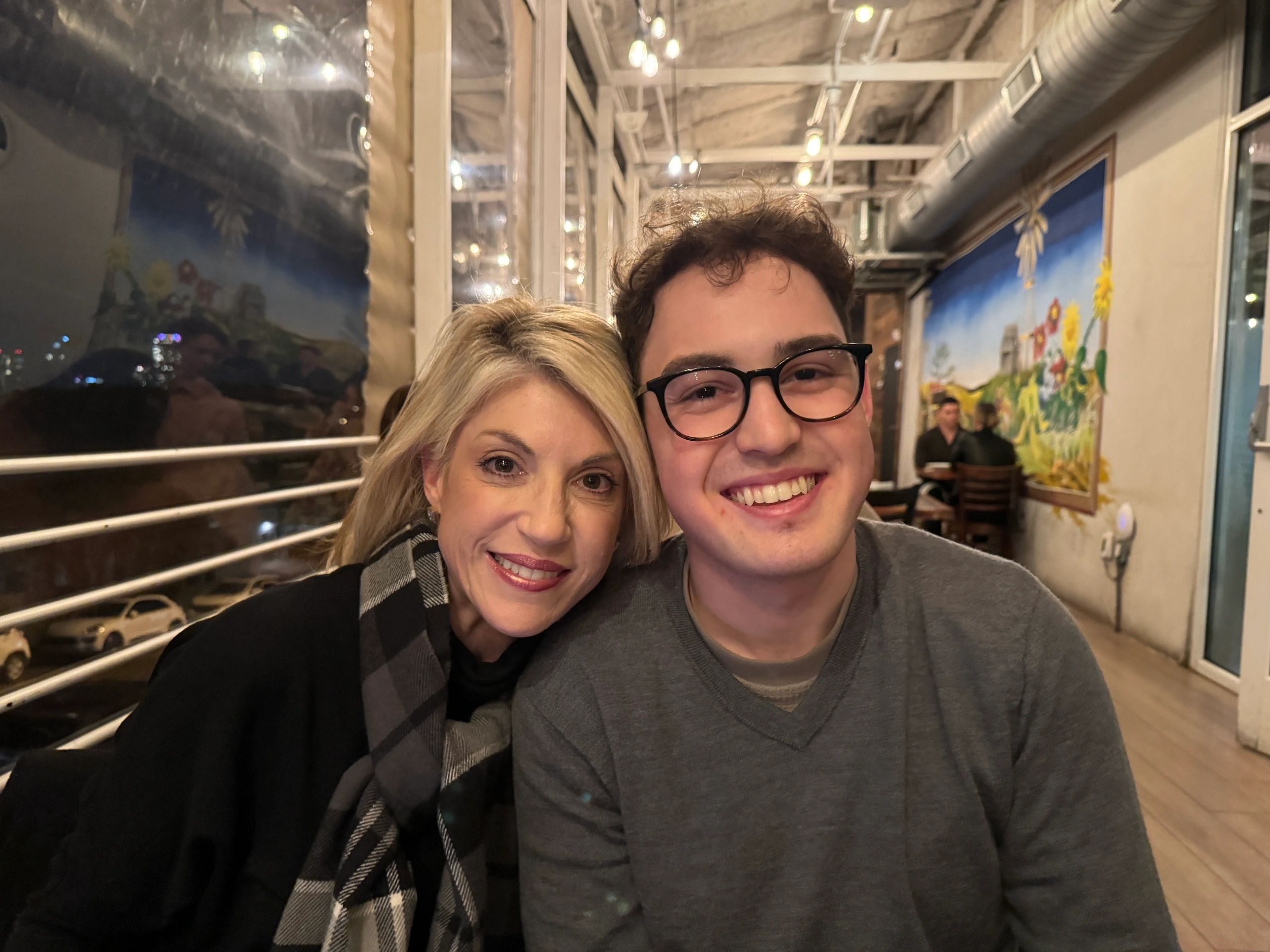 Smiling duo in a cozy restaurant setting.