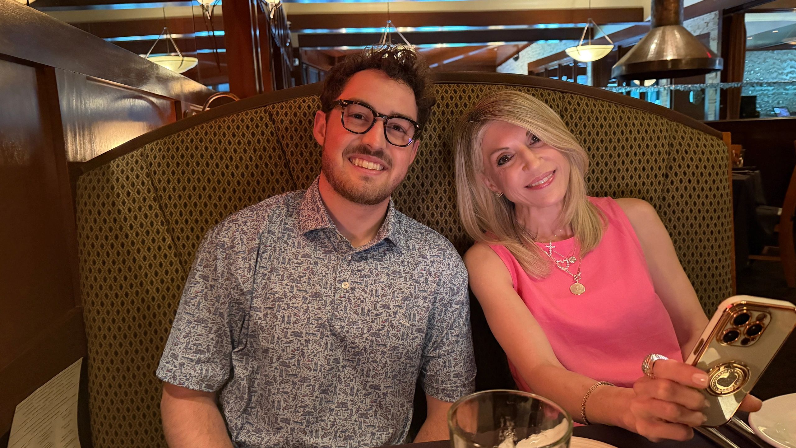 A smiling man and woman sitting close together at a restaurant booth.