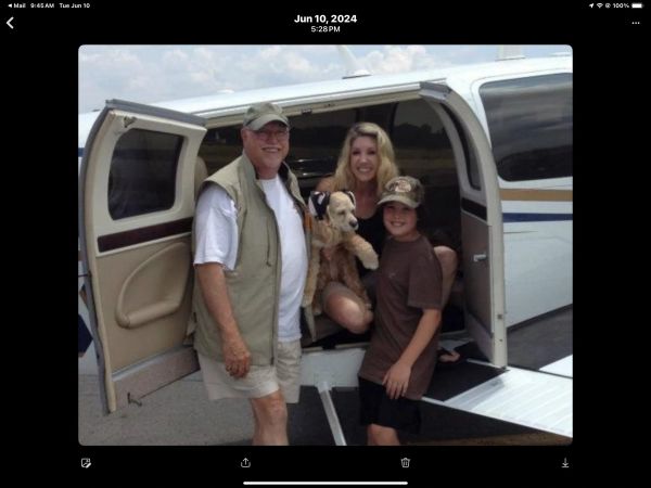 Family with a dog boarding a small private plane.