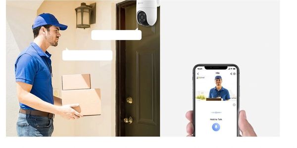 Delivery person holding packages at door with security camera and phone app.