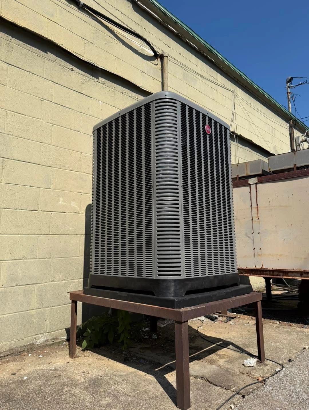 Large outdoor air conditioning unit on metal stand.