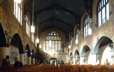 Interior of a historic church with high arched ceilings and stained glass windows.