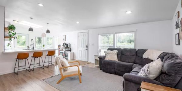 Bright living room with kitchen bar and modern furniture.
