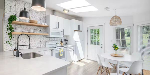 Bright, modern white kitchen with dining area.