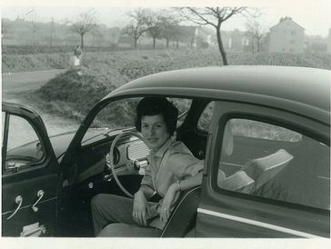 A black-and-white photo of a woman in a car