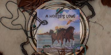 A book titled 'A Horse's Love' surrounded by horse tack and a lasso.