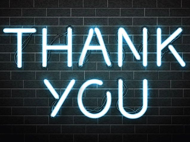 Neon sign glowing with "THANK YOU" against a dark brick wall.