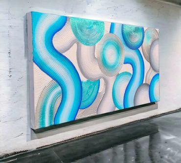 Abstract wall art with swirling blue and turquoise patterns on a textured white background.