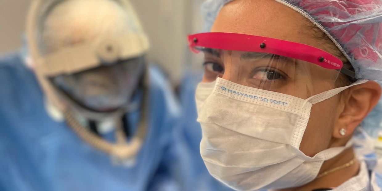 Healthcare worker wearing a face mask and shield.