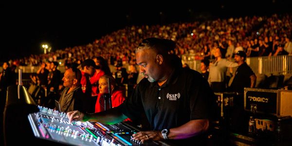 Sound engineer adjusting audio at a concert.