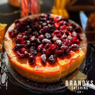 Elegant cheesecake dessert with brandy-soaked cherries for catered event