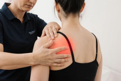 Massage Therapist assessing shoulder pain & tension during massage therapy treatment in Stittsville