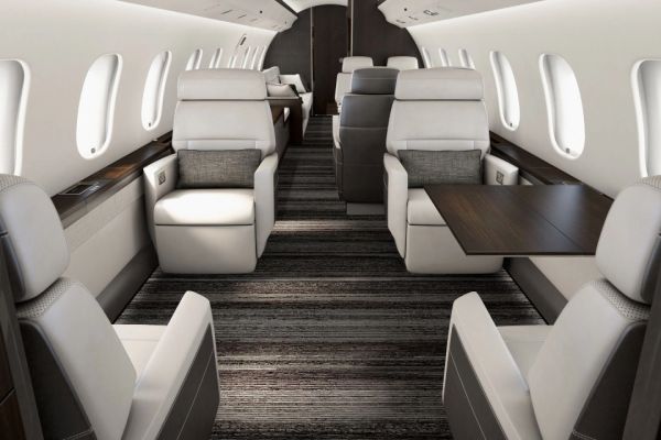 Luxurious private jet interior with spacious leather seats and wooden tables.