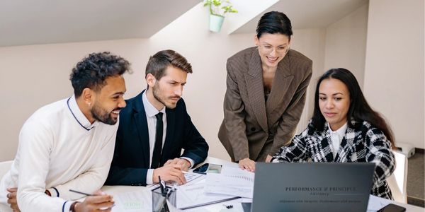 Group of professionals looking at computer in a meeting