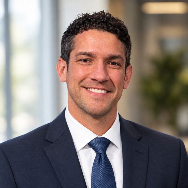 Professional man smiling in a suit and tie.