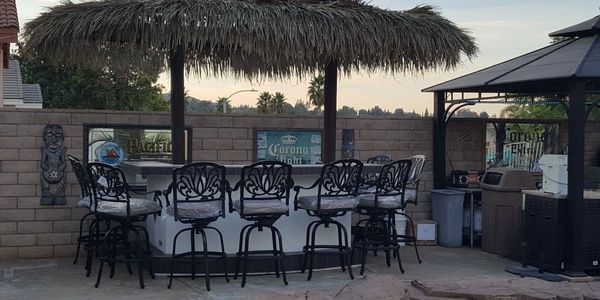 BBQ Island with Palapa surrounded by patio chairs