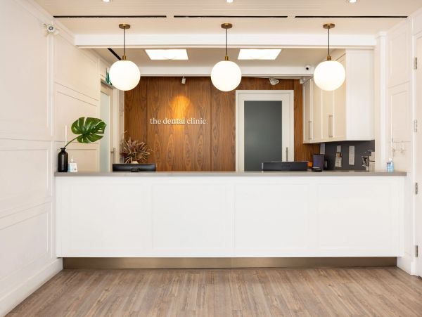 Modern dental clinic reception with clean design and warm lighting.