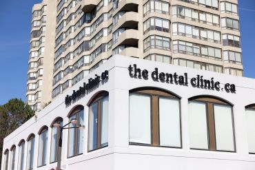 Dental clinic in a modern building under clear blue sky.