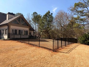 House with a fenced backyard on a sunny day.